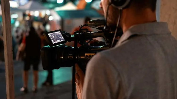 Cameraman filming a crowd at a night event