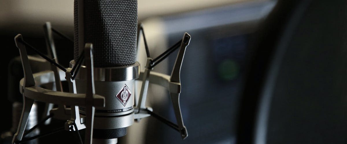 Detailed view of a condenser microphone in a recording studio setting.